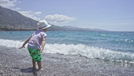 three years old child enjoys the sea at kalamata beach greece slow motion