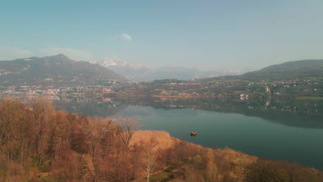 Hermosa-Vista-Del-Paisaje-Del-Idílico-Lago-Con-Montañas-De-Fondo-En-El-Lago-Annone,-Norte-De-Italia---Drone-Aéreo-Ascendiendo