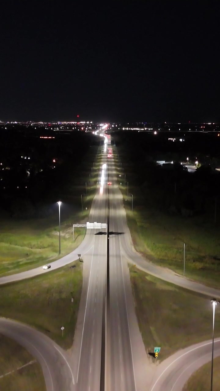 Ripresa aerea notturna verticale con drone in ascesa verso est sopra lo svincolo a quadrifoglio della South Perimeter Highway e della Pembina Highway a Winnipeg, Manitoba, Canada
