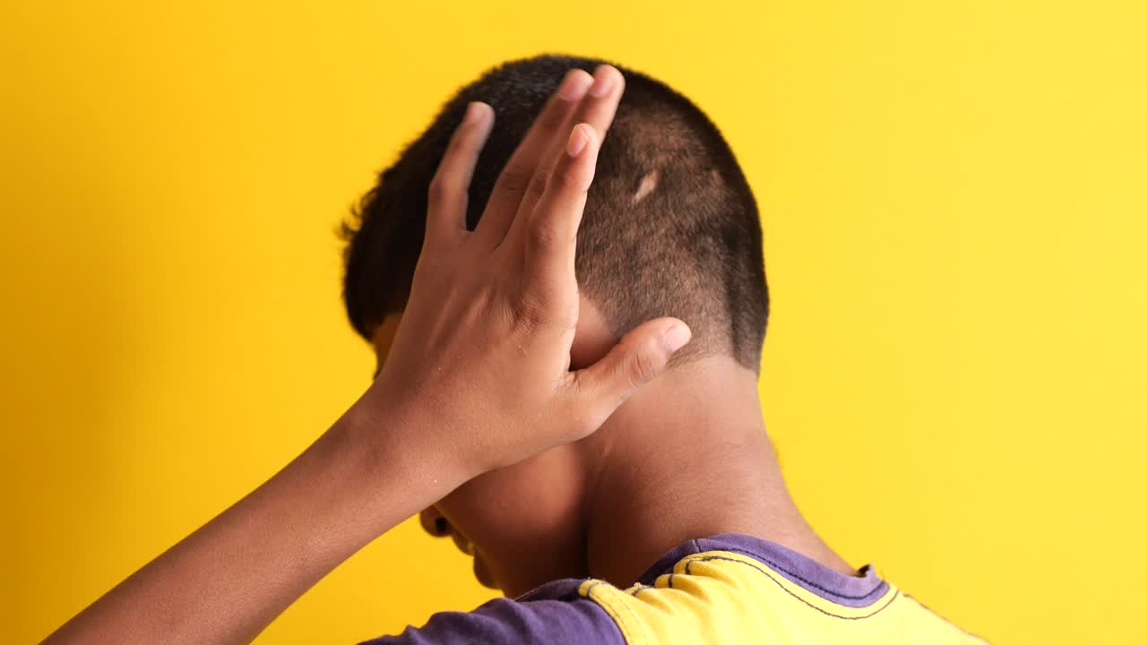 고통 속에서 귀를 만지는 소년