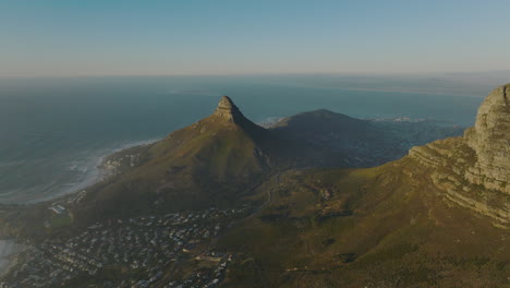 Forwards-fly-above-Table-Mountain-National-Park.-Hills-and-rock-summits-of-mountains-around-city.-Ocean-in-background.-Cape-Town,-South-Africa