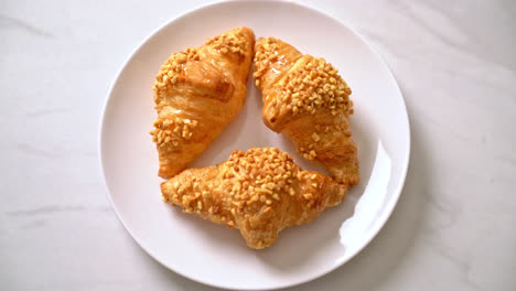 新鮮的 croissant 和花生在盤子上