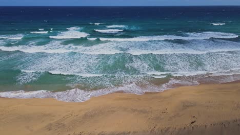 Océano-Ondeante,-Playa-De-Arena-Con-Drone