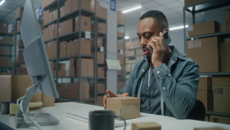empleado del almacén en teléfono y computadora