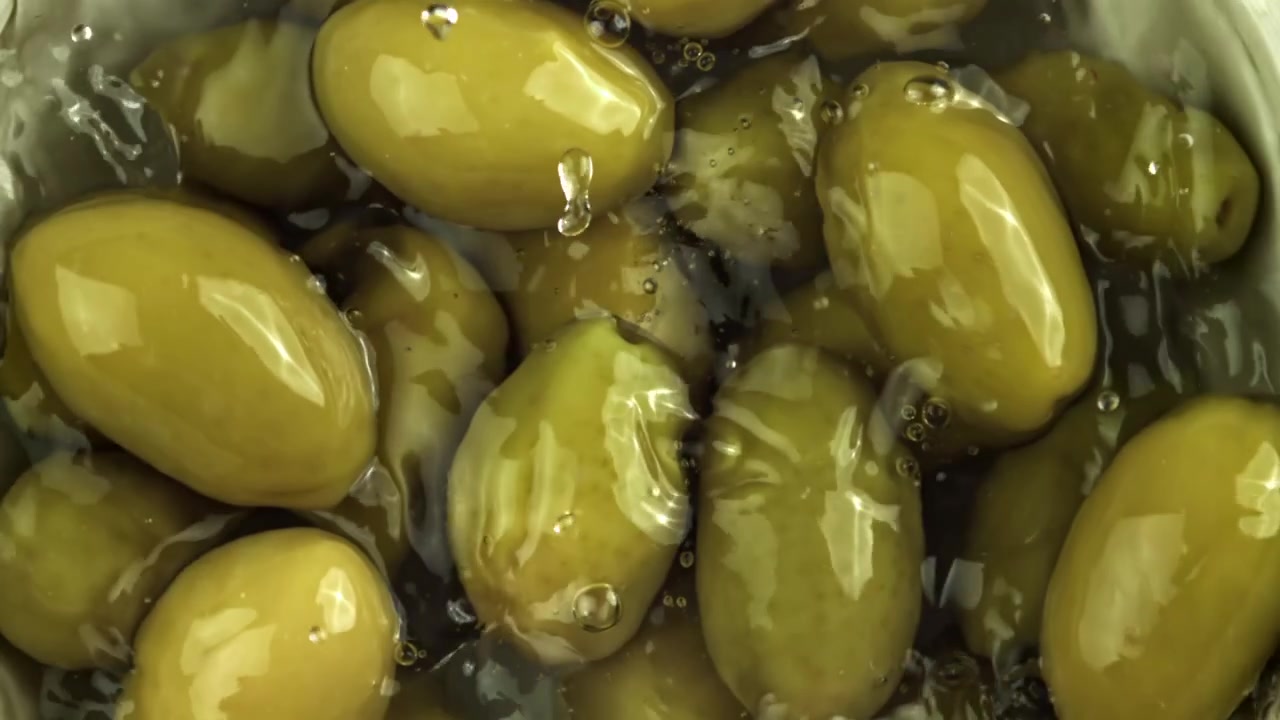L'acqua si riversa su olive verdi fresche al rallentatore.