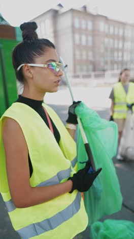 mujer voluntaria limpiando la basura en la calle