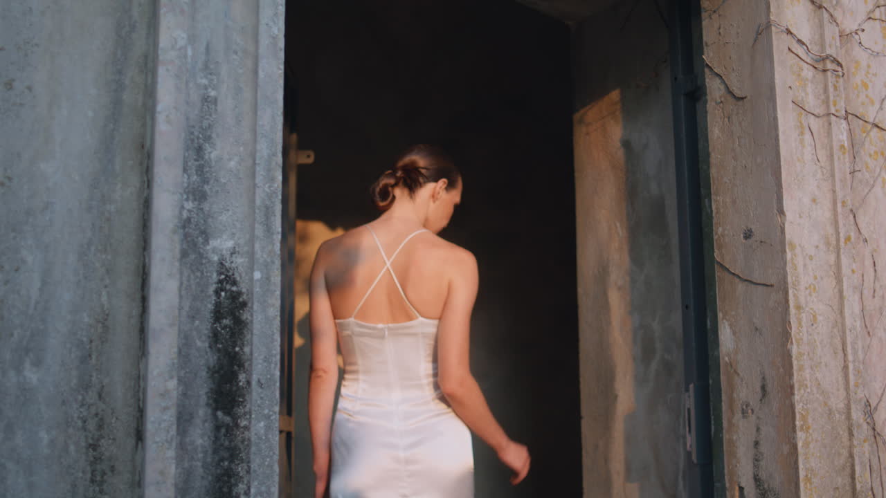 중세 성을 즐기는 패션 여성은 돌의 아치에서 고 궁전으로 들어가는 소녀입니다.