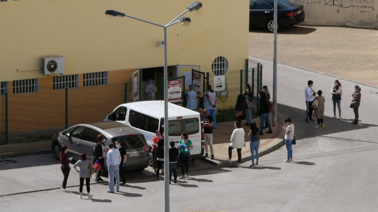 Large group of people waiting on street to get corona virus test, Portugal