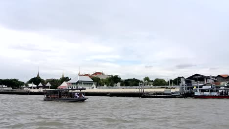 view of river embankement with buddhist temple in the background