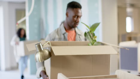 casual diverse businesspeople carrying boxes moving into office, slow motion with copy space