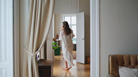 dancing lady moving slowly at beige apartment. lazy girl enjoying weekends alone