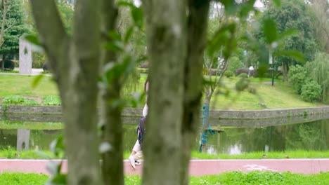 loving mother meets her son with school backpack from classroom, holds for hand and taking to home passing through green park in morning sunny day. happy family