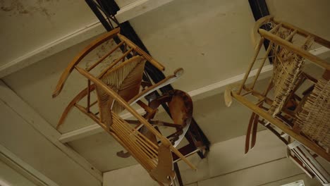 woodworking rocking chairs hanging from ceiling of carpenter shop to dry finish