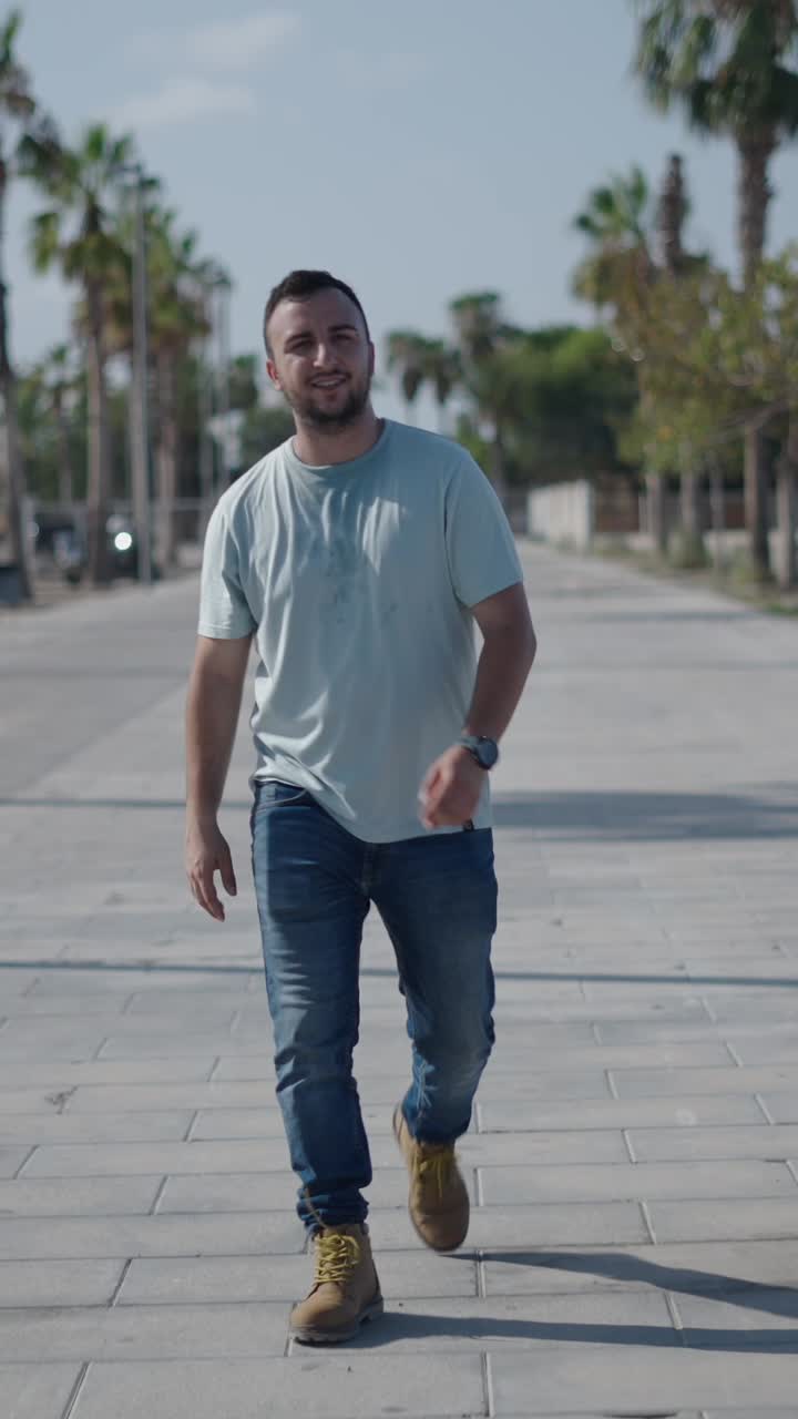 Un uomo che cammina su una strada asfaltata con palme
