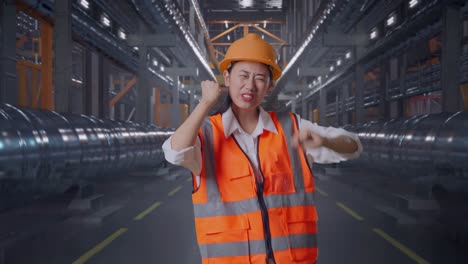 asian female engineer with safety helmet screaming goal and dancing celebrating with metal pipes