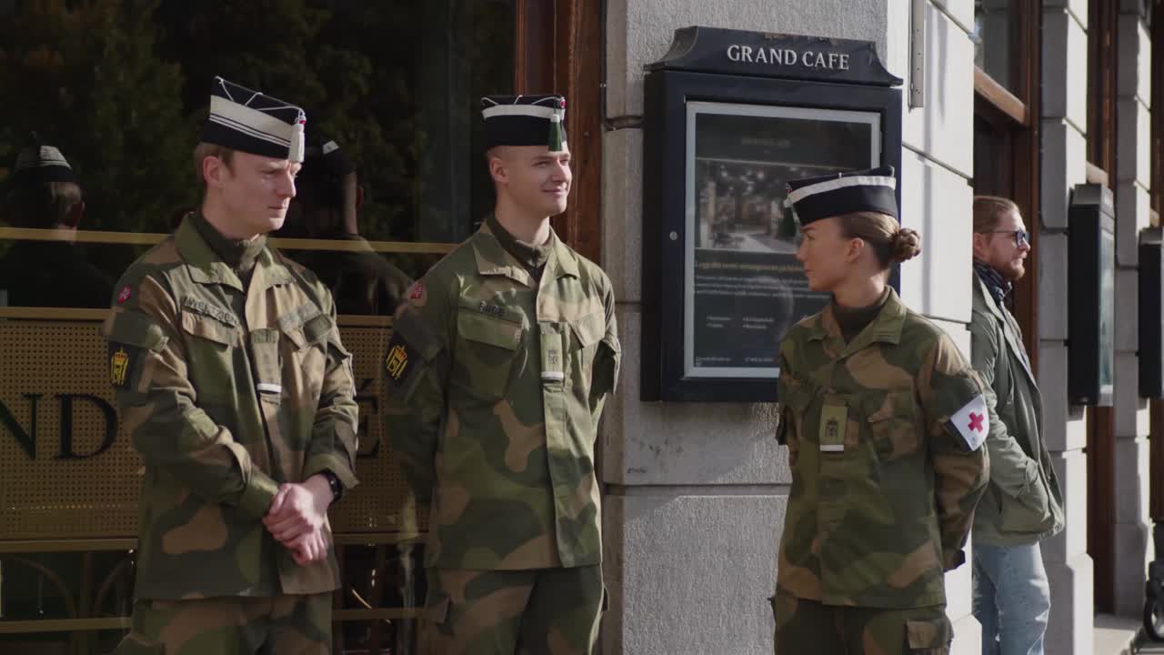 Soldiers standing in front of cafe on Karl Johan, Oslo during military parade