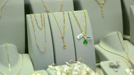 hay pendientes de oro y joyas en la ventana de la joyería jwe