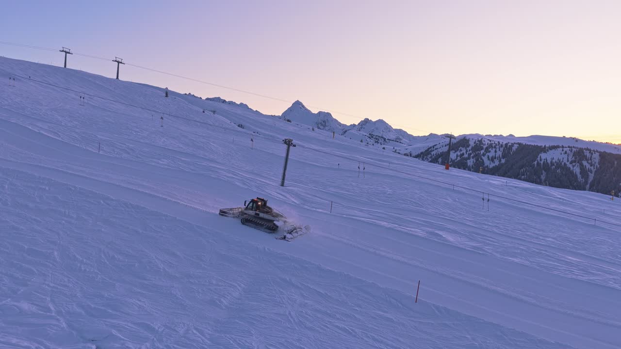 Drone captures snow groomers preparing ski pistes in Zillertal Arena, Krimml and Königsleiten, Austria, with massive snow and alpine peaks