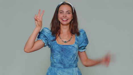 encantadora mujer feliz mostrando el signo de la victoria, esperando el éxito y la victoria, haciendo un gesto de paz, sonriendo