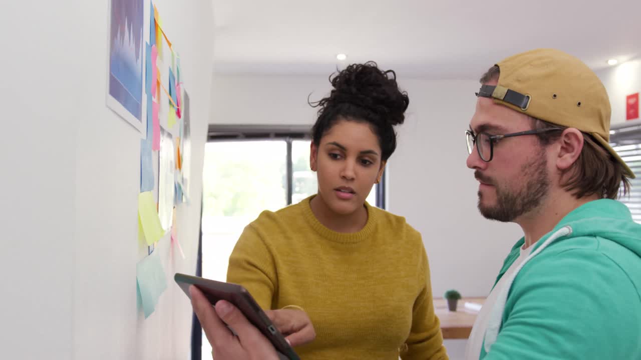 hombre caucásico y mujer de raza mixta trabajando en una oficina creativa