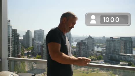 hombre enviando mensajes de texto en su teléfono mientras se apoya en los rieles de la terraza