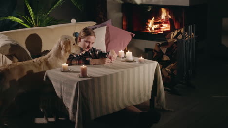 woman and dog relaxing by the fireplace at night