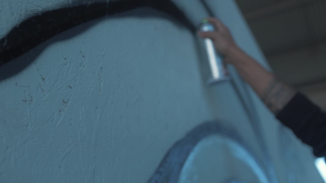 벽 추적에 선 낙서를 뿌리는 아티스트는 슬로우 모션을 사용할 수 있습니다.