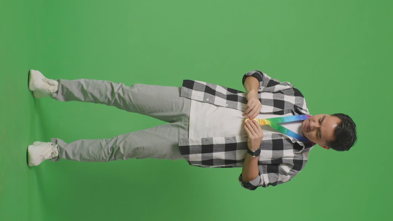 hombre con una medalla de oro y una cinta de orgullo