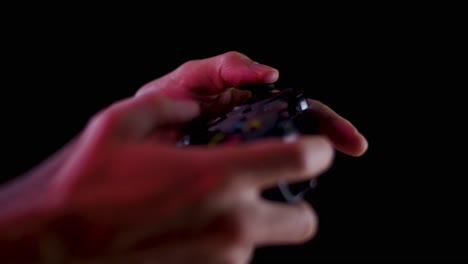 playing video games in a darkened room with a black background close up on a controller joystick playing quickly