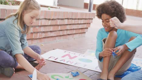 Vídeo-De-Diversos-Escolares-Haciendo-Pancartas-De-Protesta-En-El-Patio-De-La-Escuela,-Espacio-Para-Copiar