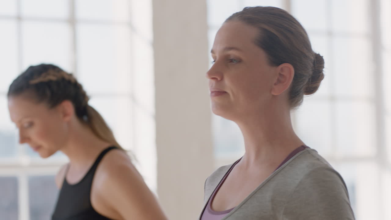 retrato de clase de yoga joven mujer embarazada caucásica practicando poses sosteniendo el vientre disfrutando de ejercicio grupal en el gimnasio