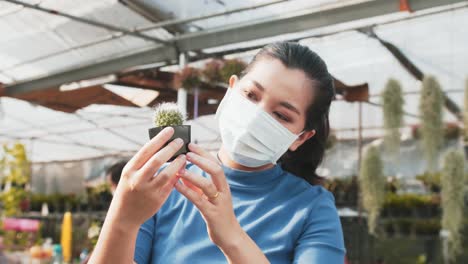 portrait of young asian agriculture scientist inspecting miniature cactus plant