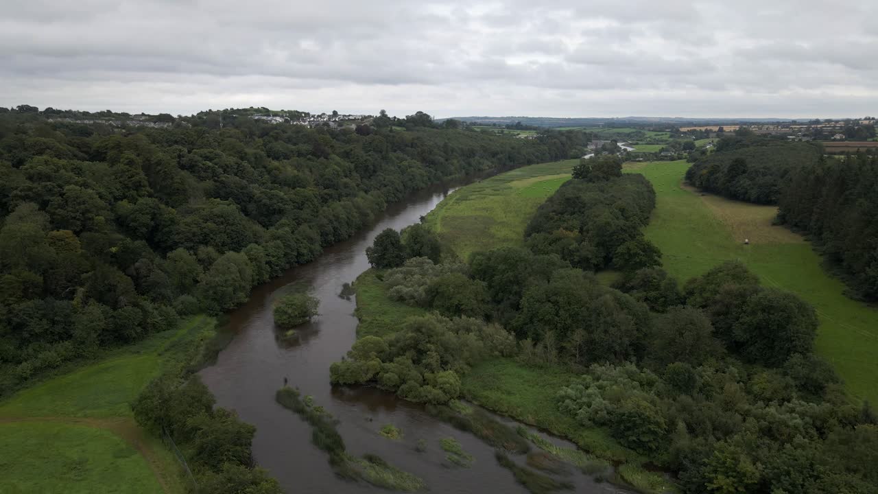 Imagem de drone de um rio grande fluindo por campos verdes na Irlanda