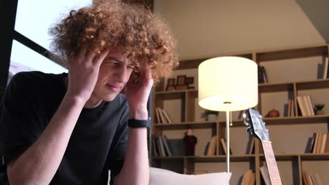 a young man with a strange hairstyle is talking on the phone a young man with a strange hairstyle is talking on the phone happy curly redhaired young man talking on the phone technologies and communications