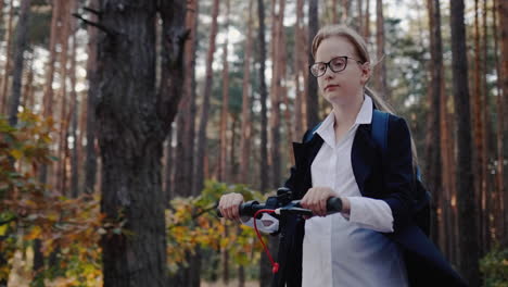 a girl in school uniform rides an electric scooter through the park