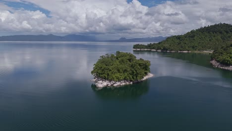 drone circling around small island in lake mainit, surigao del norte, philippines