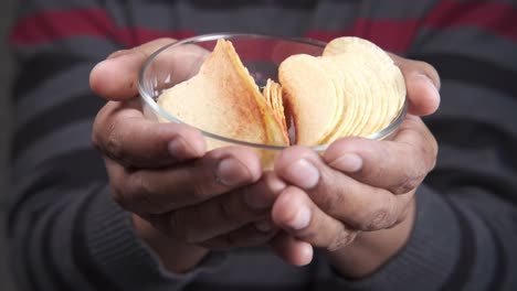 persona que sostiene un plato de papas fritas