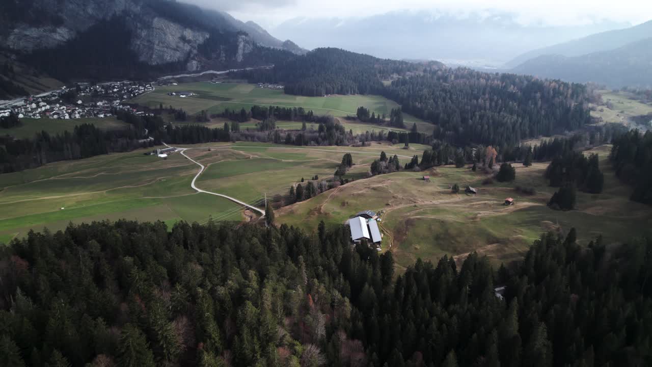 vista aérea de un paisaje en suiza con montañas, campos, bosques y pequeños pueblos