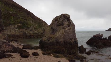 Rising-aerial-view-flying-over-large-boulder-formation-on-the-Irish-sea-coast