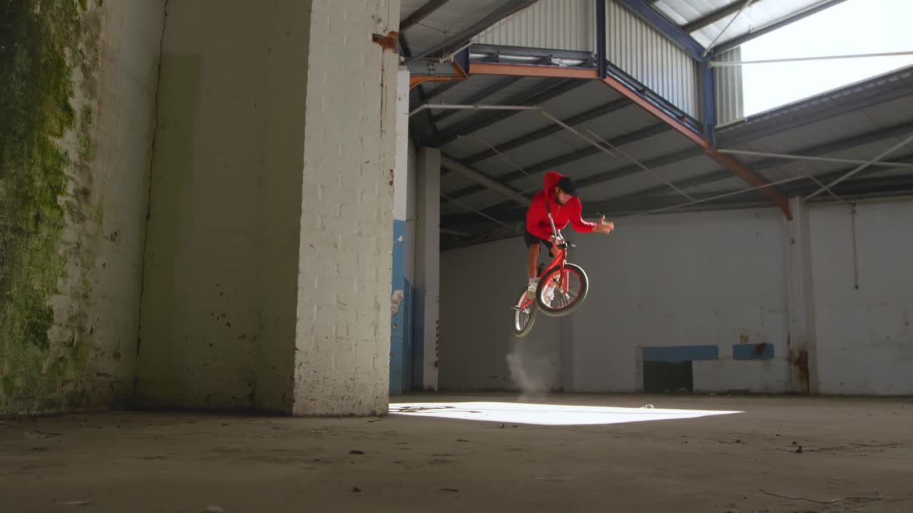 jinete de bmx en un almacén vacío