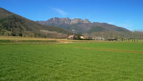 Bilder-Mit-Gimbal-Auf-Einer-Bewirtschafteten-Grünen-Wiese-Und-Bergen-Im-Hintergrund,-Vorwärtsbewegung