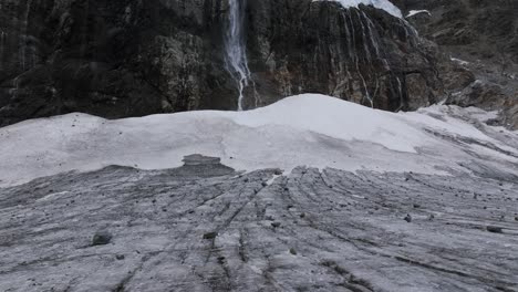 Fellaria-Glacier-with-waterfall-and-rocky-mountains-in-background,-Valmalenco-in-Italy