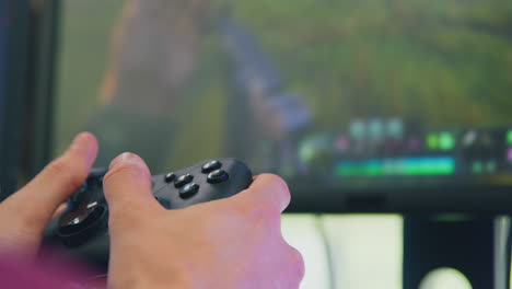 close up of man holding game controller playing shooting game online