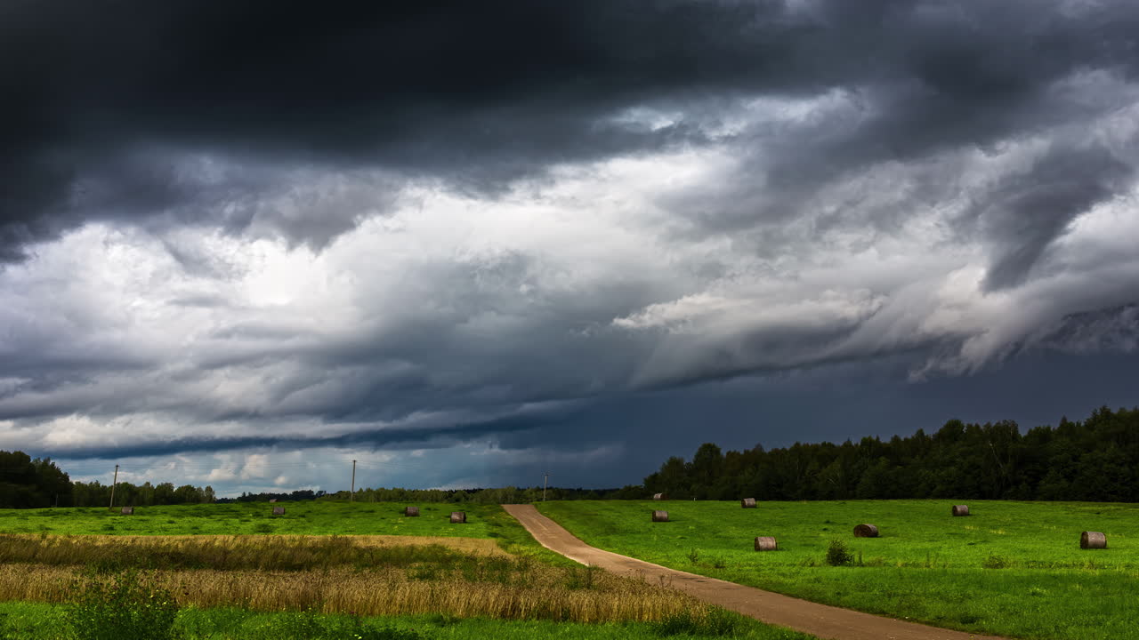 Timelapse: Mørke, mystiske skyer og skylandskaber, der flyver på himlen over en landbrugsmark i naturen.