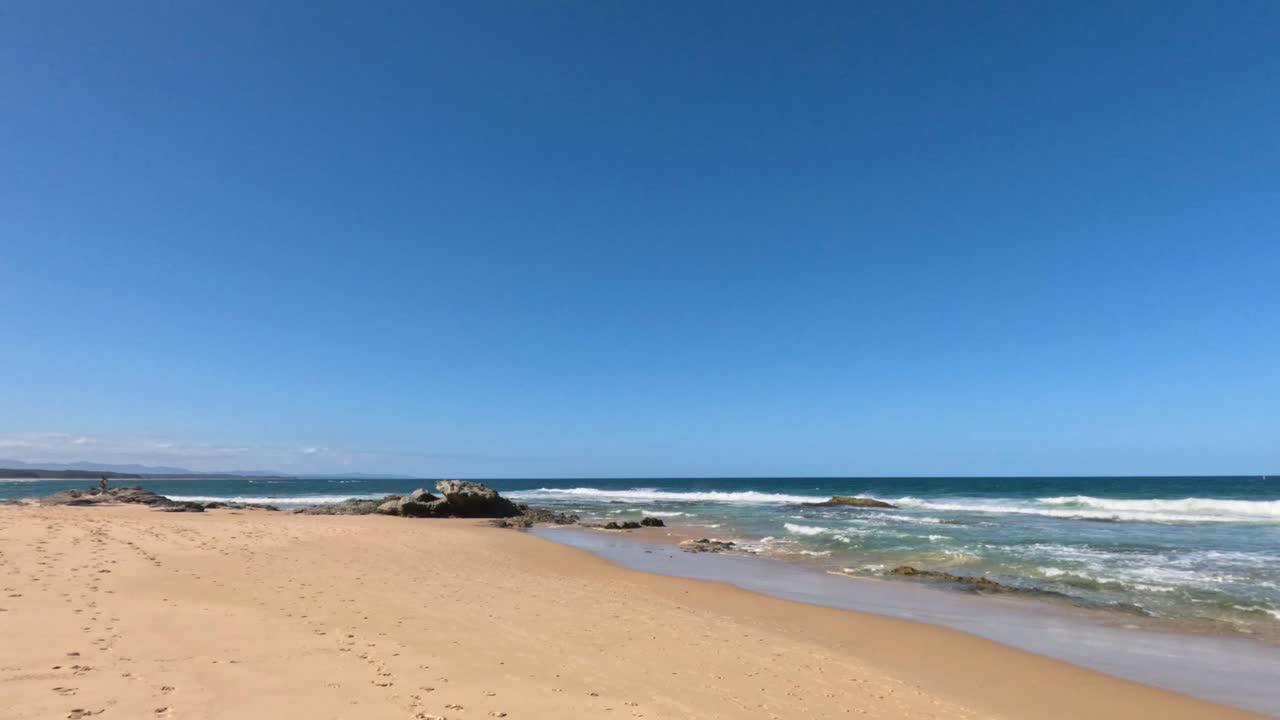 모래 해변 에 부드럽게 굴러가는 파도