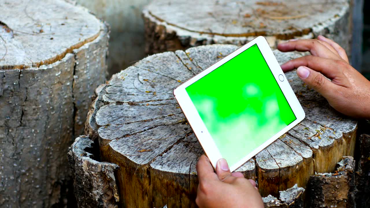 녹색 화면 을 가진 테이블 에 디지털 태블릿 을 사용 하는 사람