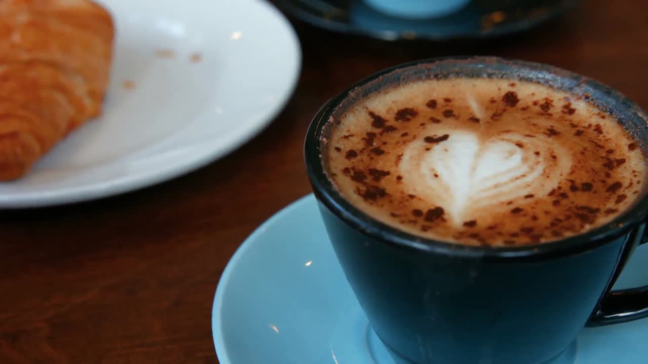 croissant y capuchino en la mesa del café