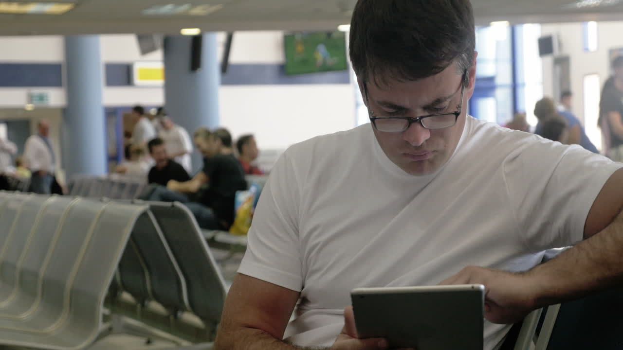 joven trabajando con un touchpad en el aeropuerto
