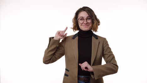 young pretty woman in stylish glasses and brown jacket looks confused and thoughtful then gets an idea. beautiful young woman gets excited after remembering something, pointing up with a finger