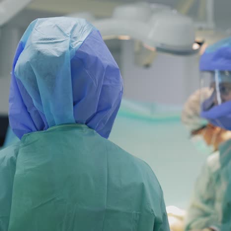 doctors in safety suits. team of medical specialists in protective uniform work together in operating room during coronavirus epidemic. back view